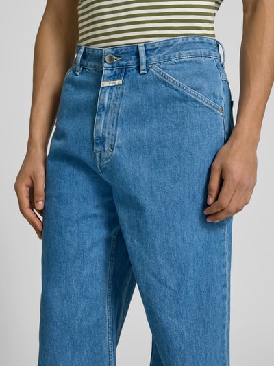 Männermodel trägt Straight Fit Jeans mit Logo-Patch von Closed, reine Baumwolle, Eingriff- und Gesäßtaschen, Nahaufnahme Oberkörper.
