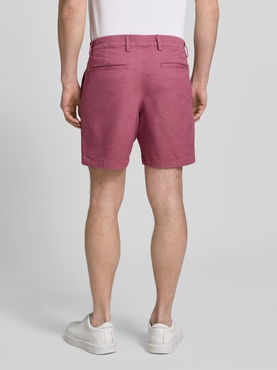 Męski model nosi szorty mit französischen Eingrifftaschen von GAP w kolorze różowym, mieszanka bawełny z dodatkiem streczu, krój straight fit, zapięcie na guzik i zamek błyskawiczny, wpuszczane kieszenie i kieszenie z tyłu, szerokość w rozmiarze 32: 43 cm, długość wewnętrzna nogawki: 18 cm, całkowity widok z tyłu.