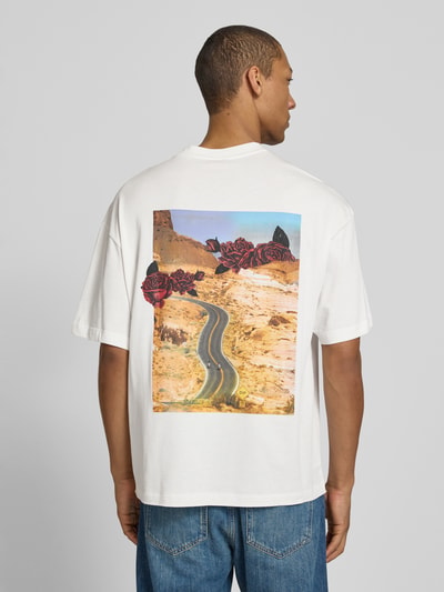 Männermodel trägt Oversized T-Shirt aus reiner Baumwolle Modell 'DOMANS' von HUGO in Weiß mit Foto-Print und Label Stitching, Ganzkörperansicht Rückansicht.
