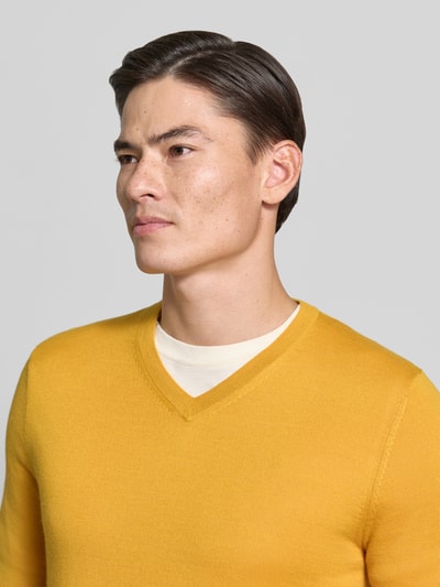 Männermodel trägt Strickpullover aus Woll-Mix mit V-Ausschnitt von Christian Berg Men in Gelb, Regular Fit, Nahaufnahme Oberkörper.