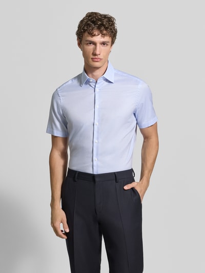 Männermodel trägt Regular Fit Business-Hemd mit Kentkragen von Christian Berg Men in Hellblau, aus reiner Baumwolle, Nahaufnahme Oberkörper.