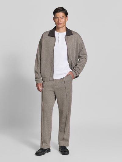 Männermodel trägt Straight Fit Stoffhose aus Baumwoll-Mix von DRYKORN in Beige, sichtbare Bundfalten, seitliche Eingrifftaschen, Ganzkörperansicht von vorne. Innenbeinlänge bei Größe M: 73 cm, Gesäßtasche, glatte Textur