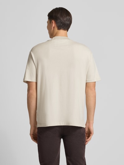 Männermodel trägt T-Shirt mit Label-Detail von Guess aus reiner Baumwolle, lockerer Schnitt, gerippter Rundhalsausschnitt, Rückenlänge 73 cm, Ganzkörperansicht Rückansicht.