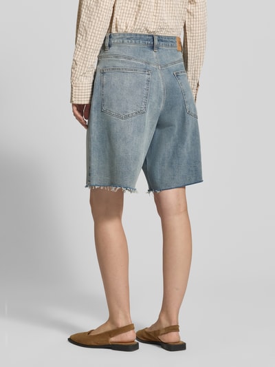 Frauenmodel trägt Wide Leg Jeansshorts im 5-Pocket-Design von Gestuz aus blauem Baumwoll-Mix, mit Bundweite 39 cm, Innenbeinlänge 26 cm, Ganzkörperansicht Rückansicht.