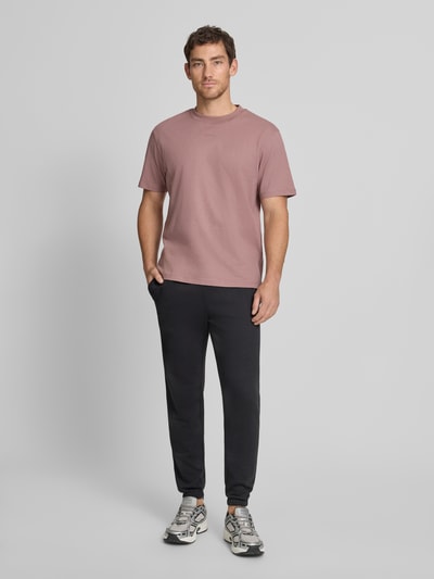 Männermodel trägt Sweatpants mit Logo und elastischem Bund von GAP aus Baumwoll-Mix, Regular-Fit, dunkle Farbe, Ganzkörperansicht von vorne.