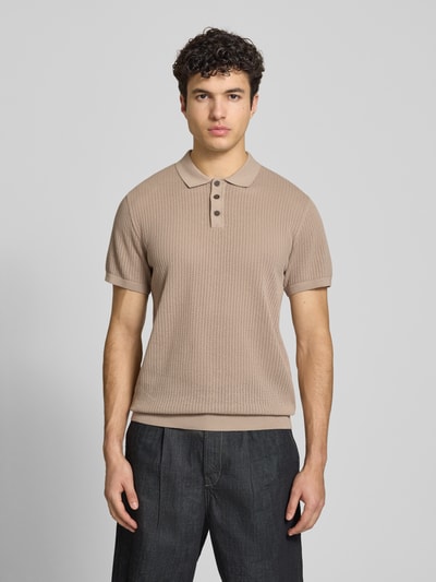 Męski model nosi Modern Fit Poloshirt mit kurzer Knopfleiste Modell 'JESS' od Jack & Jones, bawełniany miks, półprzezroczysty, beżowy, krótki rękaw, kołnierzyk polo, przód koszulki z fakturą, długość tyłu w rozmiarze M 68 cm, widok całej sylwetki z przodu.
