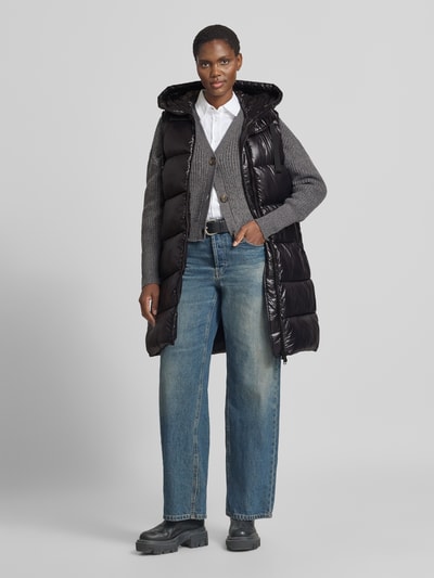 Vrouwenmodel draagt zwarte bodywarmer met tweewegritssluiting van Save The Duck, A-lijn, capuchon met tunnelkoord, ritszakken, ruglengte 92 cm, schouderbreedte 39 cm, borstwijdte 50 cm, Model 'IRIA', kleuren zwart en grijs, glanzende textuur, vooraanzicht volledige lichaamsopname.