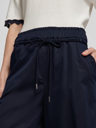 Frauenmodel trägt Culotte mit elastischem Bund und Bindegürtel von Marc Cain, Baumwoll-Mix mit Viskose-Anteil, Nahaufnahme Oberkörper.