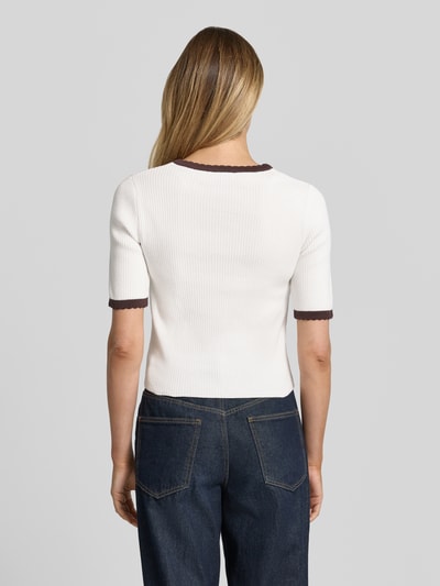 Frauenmodel trägt Slim Fit Cardigan in Strick-Optik von More & More aus Reine Baumwolle mit Rundhalsausschnitt, Halbarm, cremeweiß mit dunklen Bündchen, Rückenlänge bei Größe 36: 42 cm, Ärmellänge: 28 cm, durchgängige Knopfleiste, Struktur fein gerippt, Ganzkörperansicht Rückansicht.