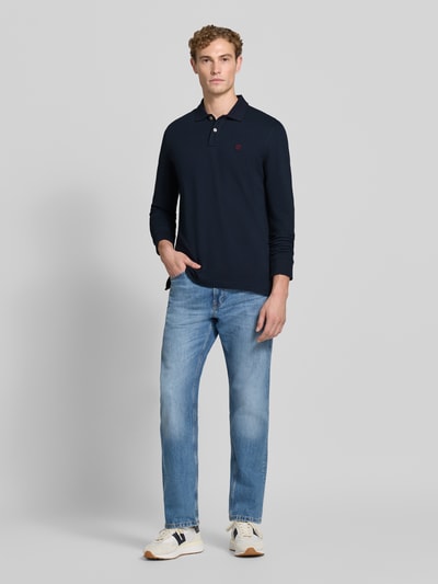 Mannenmodel draagt Regular Fit poloshirt uit puur katoen van MCNEAL, polokraag met knoopsluiting, labelstitching, shirt met lange mouwen, ruglengte bij maat M 73 cm, donkerblauw, lichte jeans, volledig lichaam vooraanzicht.