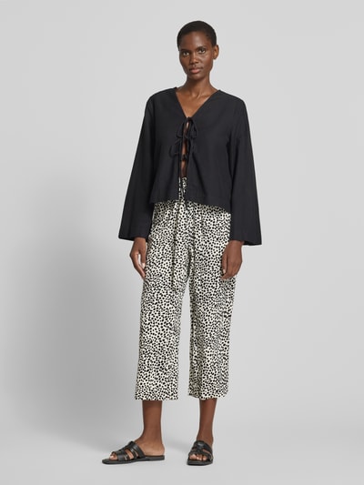 Frauenmodel trägt Culotte mit Bindegürtel Modell 'JOSA' von Vila im Loose-Fit-Design, schwarz-weiß gemustert, Seitliche Eingrifftaschen, Ganzkörperansicht von vorne.