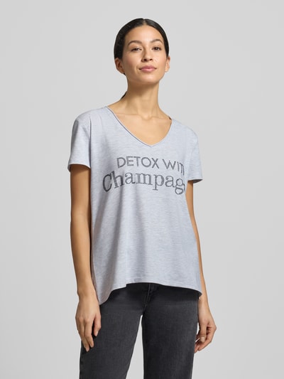 Frauenmodel trägt T-Shirt mit Label-Detail von miss goodlife in Hellgrau, V-Ausschnitt, lockerer Schnitt, Baumwoll-Elasthan, Ganzkörperansicht von vorne.
