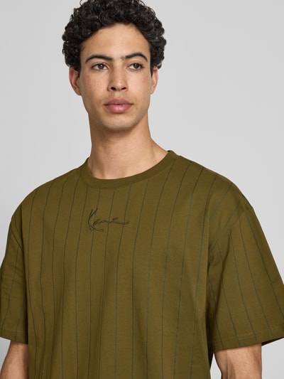 Männermodel trägt Relaxed Fit T-Shirt mit Logo-Stitching von KARL KANI aus Reine Baumwolle, Rundhalsausschnitt, Nahaufnahme Oberkörper.