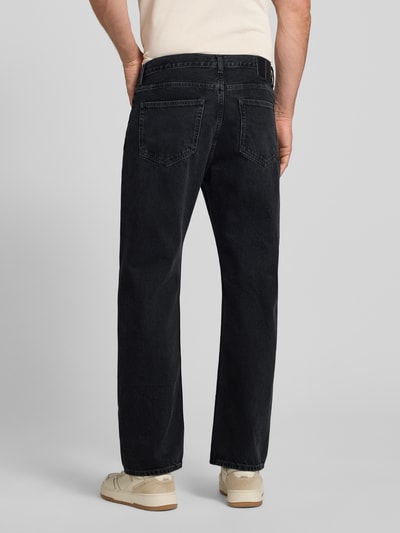 Męski model nosi Jeans mit Eingrifftaschen Modell 'Type 2' od Wood Wood, czarna bawełna, krój relaxed fit, Szerokość w rozmiarze 32/32: 43 cm, długość nogawki wewnętrznej: 76 cm, całkowity widok z tyłu.
