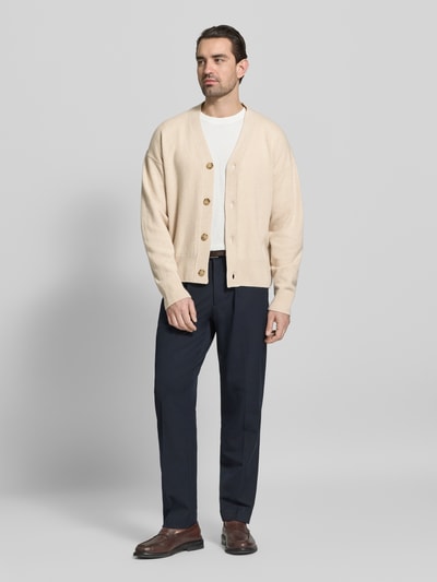 Männermodel trägt Regular Fit Strickjacke aus reiner Schurwolle Modell 'C-UCONE' von BOSS in Unifarben, Ganzkörperansicht von vorne.