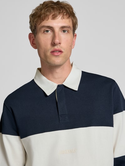 Männermodel trägt Regular Fit Poloshirt mit Label-Stitching Modell 'FREDERIKSBERG' von JACK & JONES im Colour-Blocking-Design, Nahaufnahme Oberkörper, reine Baumwolle