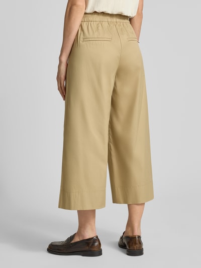 Frauenmodel trägt Culotte mit Gesäßtaschen Modell 'CAROLINE' von MAC aus Baumwoll-Mix mit Stretch-Anteil in Beige, Ganzkörperansicht Rückansicht.