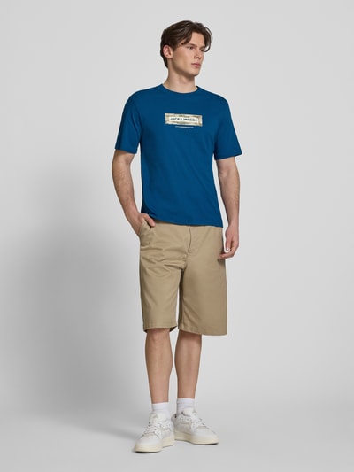 Männermodel trägt T-Shirt mit Logo und Rundhalsausschnitt von Jack & Jones aus reiner Baumwolle, Regular-Fit, Blau, Ganzkörperansicht von vorne, Rückenlänge bei Größe M 68 cm.
