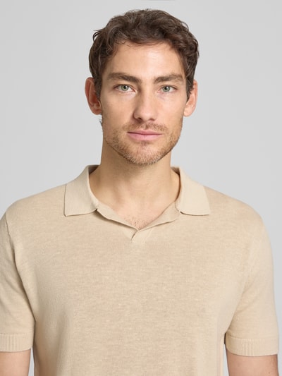 Männermodel trägt Regular Fit Poloshirt aus Baumwoll-Leinen-Mix Modell 'MATTIS' von SELECTED HOMME in Beige, Feinstrick, Nahaufnahme Oberkörper.