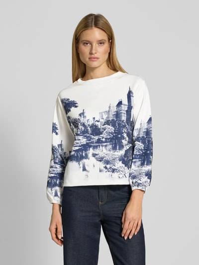 Vrouwenmodel draagt Sweatshirt im Allover-Look mit Rundhalsausschnitt van monari, regular fit, materiaal-mix met stretch, allover blauw-wit patroon, vooraanzicht bovenlichaam.