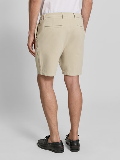 Männermodel trägt Modern Fit Chinoshorts aus Baumwoll-Mix Modell 'KANE1' von BOSS in Beige, unifarben, Ganzkörperansicht Rückansicht.