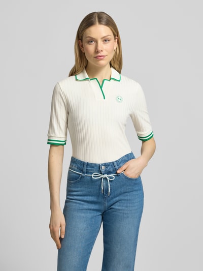Vrouwenmodel draagt Regular Fit Poloshirt aus Viskose-Mix van Marc Cain, crèmekleurig met groene details, ribstructuur, borstlogo, elastische mouwuiteinden, polokraag, elastische viscosemix, geheel van voren bekeken, context: ruglengte maat 36 59 cm, mouwlengte maat 36 30 cm.