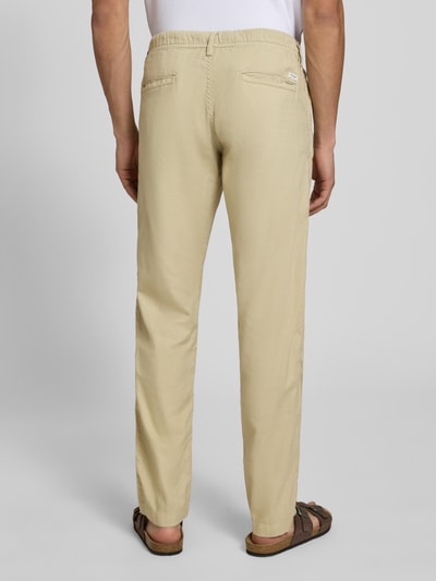 Männermodel trägt Relaxed Fit Hose aus Baumwoll-Leinen-Mix Modell 'KANE' von Jack & Jones in Beige mit elastischem Bund und Gesäßtaschen, Ganzkörperansicht Rückansicht.