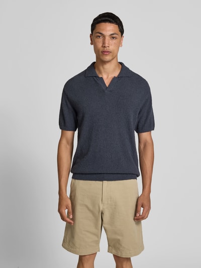 Männermodel trägt Regular Fit Poloshirt in Strick-Optik von Closed, dunkelblau, Baumwoll-Mix, Polokragen, kurzärmelig, Ganzkörperansicht von vorne.