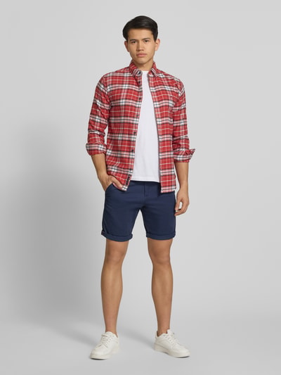 Männermodel trägt Regular Fit Shorts mit Eingrifftaschen Modell 'BOWIE' von Jack & Jones, dunkelblau, aus Baumwoll-Elasthan-Mix, Ganzkörperansicht von vorne.