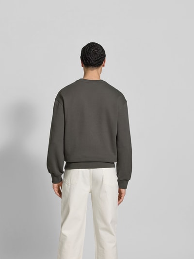 Männermodel trägt Sweatshirt aus Baumwoll-Mix von MAISON KITSUNÉ in Dunkelgrau mit Rundhalsausschnitt, lockere Passform, Ganzkörperansicht Rückansicht.