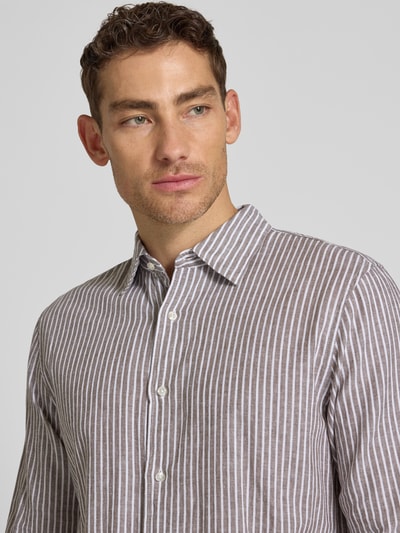 Męski model nosi Regular Fit Freizeithemd aus Leinen-Mix mit Kentkragen od MCNEAL, paski, jasnobrązowy z białym, krój regular fit, długi rękaw, len z bawełną, guzik, sportowe mankiety, długość pleców w rozmiarze L: 77 cm, szerokość w rozmiarze L: 50 cm, długość rękawa w rozmiarze L: 67 cm, zbliżenie na górną część tułowia