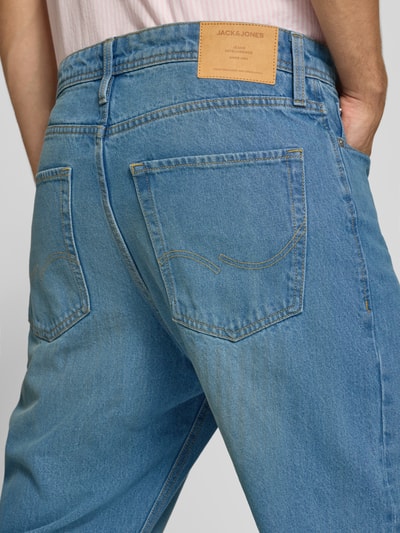 Männermodel trägt Straight Fit Jeans aus reiner Baumwolle Modell 'Alex' von JACK & JONES, mittleres Blau, 5-Pocket-Design, Ganzkörperansicht Rückansicht.