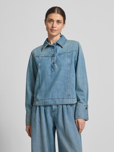 Kobiece modelka ma na sobie bluzkę jeansową Regular Fit w efekcie znoszenia model 'TOP TAVY' od Bash z bawełny, kołnierzyk koszulowy, listwa guzikowa, długość tyłu w rozmiarze S 55 cm, długość rękawów 62 cm, widok całej sylwetki z przodu.