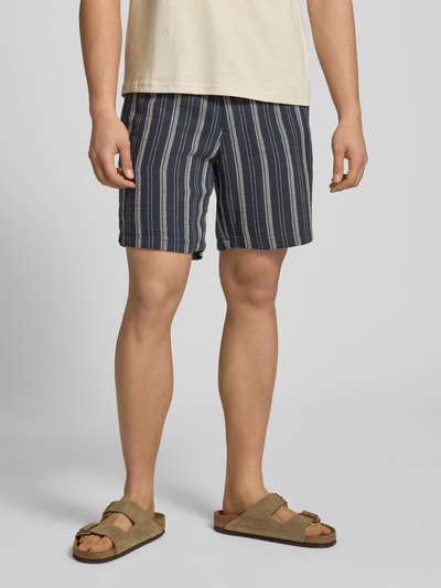 Mężczyzna nosi Shorts mit elastischem Bund und Logo-Detail von REVIEW, bawełniany miks, krój regular fit, widok z przodu, zbliżenie na dolną część ciała.