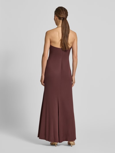 Frauenmodel trägt Abendkleid mit Neckholder in Ring-Optik von Rinascimento, figurbetonter Material-Mix in Dunkelbraun, Maxikleid, Ganzkörperansicht Rückansicht.