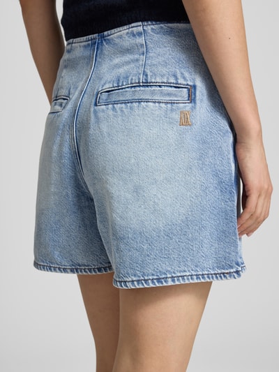 Frauenmodel trägt Hosenrock mit Gesäßtaschen von ARMANI EXCHANGE, hellblaue Denim-Optik, Baumwoll-Mix mit Stretch-Anteil, Gerader-Schnitt, Minirock, Knopfverschluss, sichtbare Gesäßtaschen, Bundweite bei Größe 36: 38 cm, Gesamtlänge bei Größe 36: 39 cm, Ganzkörperansicht Rückansicht.