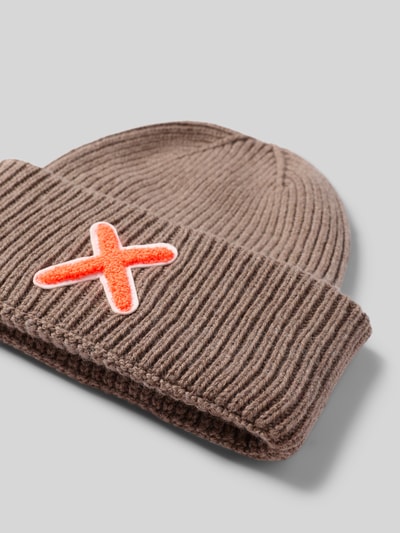 Produktfoto, Mütze aus Schurwolle-Kaschmir-Mix mit Motiv-Stitching von UNIO HAMBURG, Grobstrick, breiter Umschlag, braun mit orangefarbenem X, strukturierte Oberfläche.