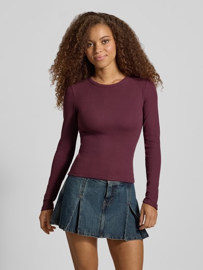 Vrouwenmodel draagt shirt met lange mouwen in bordeaux, mix van katoen en elastaan, skinny fit, ronde hals, riblook, Model 'FREYA' van JJXX, ruglengte maat S 50 cm, geheel van voren