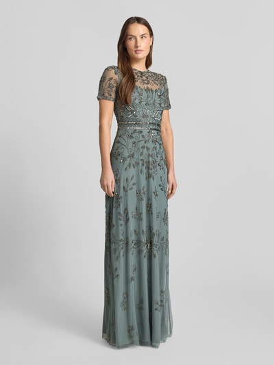 Frauenmodel trägt Abendkleid mit Zierbesatz von Lace & Beads, grünliches Mesh, tailliert, Rundhalsausschnitt, florale Textur, Ganzkörperansicht von vorne.