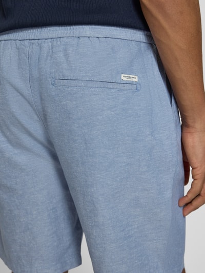 Männermodel trägt Shorts mit elastischem Bund von Scotch & Soda aus Baumwoll-Leinen-Mix in Hellblau, Regular Fit, Nahaufnahme Rückansicht.