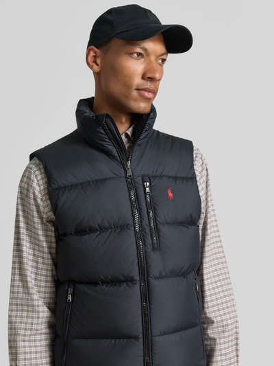 Männermodel trägt Regular Fit Weste mit Logo-Stitching von Polo Ralph Lauren in Dunkelblau, gesteppte Textur, Nahaufnahme Oberkörper. Herren Weste von Polo Ralph Lauren