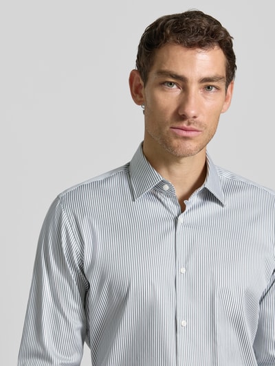 Männermodel trägt Regular Fit Businesshemd aus Baumwoll-Mix Modell 'H-Joe-kent' von BOSS mit feinen Streifenmustern, Nahaufnahme Oberkörper. Herren Businesshemd von BOSS.