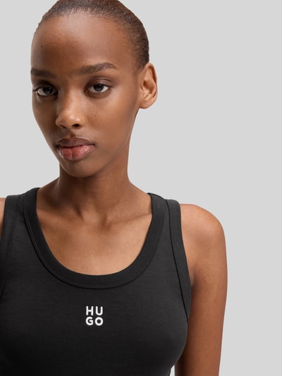 Frauenmodel trägt Slim Fit Tank Top aus Baumwoll-Mix Modell 'DATAMIA' von HUGO in Schwarz mit Label Stitching und U-Ausschnitt, Nahaufnahme Oberkörper.