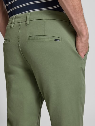 Männermodel trägt Straight Fit Chino mit Gesäßtaschen Modell 'Stollie' von JACK & JONES aus grünem Baumwoll-Mix, Detailaufnahme Rückansicht. Herren Chino mit Eingrifftaschen, Knopf- und Reißverschluss, Maße bei Größe 32/32: Bundweite 44 cm, Innenbeinlänge 75 cm.