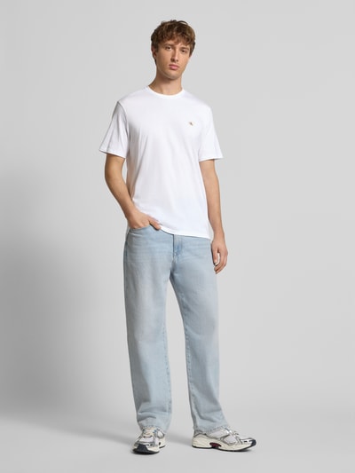 Männermodel trägt T-Shirt mit Label-Detail im 2er-Pack von Calvin Klein Jeans, weiße reine Baumwolle, Regular-Fit, Ganzkörperansicht von vorne.