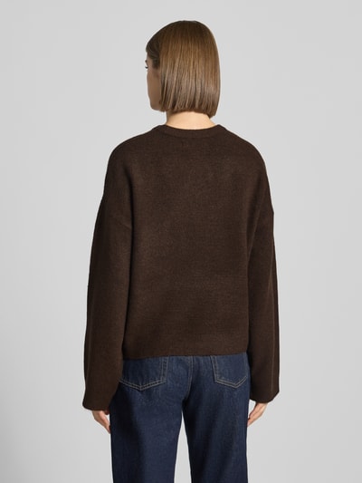 Frauenmodel trägt Relaxed Fit Pullover mit Rundhalsausschnitt Modell 'SIMONI' von ONLY in Dunkelbraun, grobe Struktur, Ganzkörperansicht Rückansicht, Damen Pullover von ONLY.