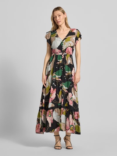 Frauenmodel trägt Maxikleid aus Viskose mit V-Ausschnitt von Apricot, taillierte Passform, Volants, Eingrifftaschen, florales Muster, Ganzkörperansicht von vorne.