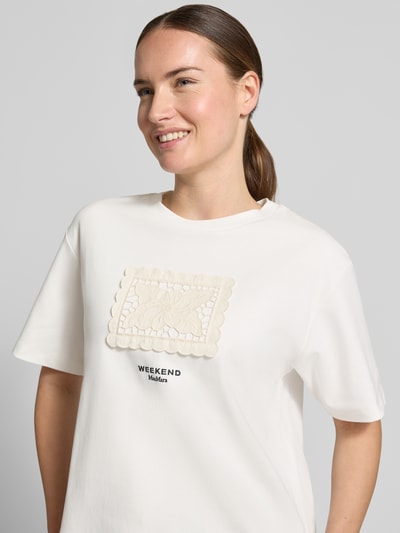 Vrouwenmodel draagt Boxy Fit t-shirt uit puur katoen model 'SALA' van Weekend Max Mara, wit met geborduurde applicatie, Nahaufnahme Oberkörper.