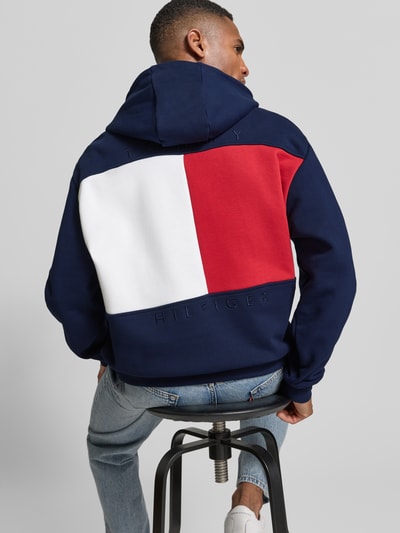 Männermodel trägt Regular Fit Hoodie aus reiner Baumwolle von Tommy Hilfiger, Optik: Unifarben, Logo-Applikation, Sweat, Ganzkörperansicht Rückansicht.