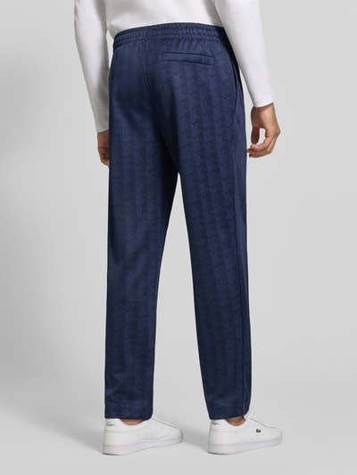 Männermodel trägt Regular Fit Sweathose aus mit Logo-Print von Lacoste in Dunkelblau mit feinem Muster, Herren Sweathose, Ganzkörperansicht Rückansicht.